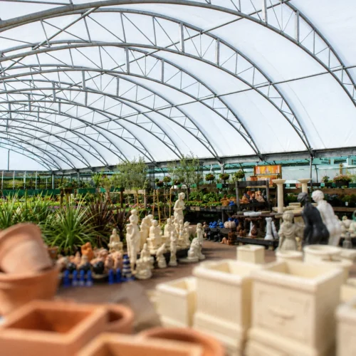 Large-span garden centre canopy providing a bright, weather-protected retail space for plants, pots and garden products