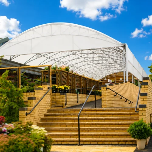 Large-span garden centre canopy creating a bright, weather-protected retail and plant display area