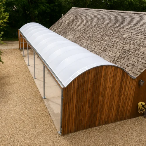 Bespoke covered walkway canopy providing sheltered access alongside a timber-clad building
