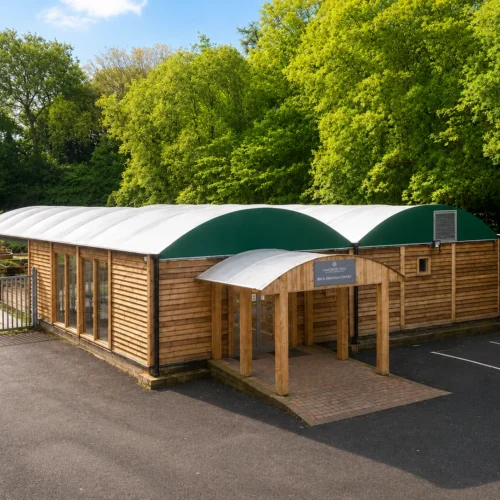 Bespoke timber-clad visitor centre at Samlesbury Hall featuring a curved canopy roof structure